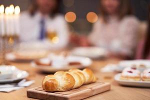 Chanoeka diner. familie verzameld in de omgeving van de tafel met traditioneel gerechten foto