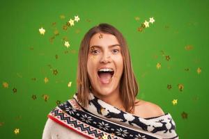 aantrekkelijk brunette vrouw met confetti over- groen achtergrond foto