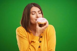 mooi vrouw poseren met donuts over- groen achtergrond foto