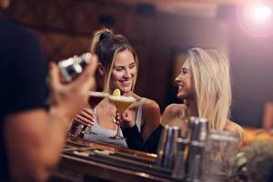 groep van vrienden genieten van drinken in bar foto