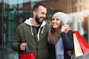 portret van gelukkig paar met boodschappen doen Tassen na boodschappen doen in stad foto