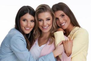 drie Dames in pastel pakken poseren over- wit achtergrond foto