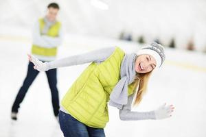 vrolijk paar in de het schaatsen baan foto