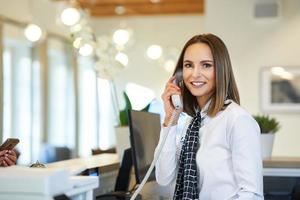 receptioniste beantwoorden telefoon Bij hotel voorkant bureau foto