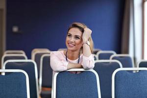 jong gelukkig vrouw zittend alleen in conferentie kamer foto