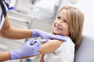 dapper weinig meisje ontvangen injectie of vaccin met een glimlach foto