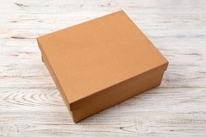 bruin Gesloten karton doos Aan een houten achtergrond. top visie, blanco voor u ontwerp foto