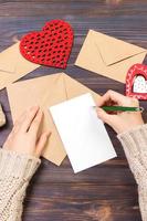 vrouw schrijven liefde brief of romantisch gedicht voor valentijnsdag dag, top visie van vrouw handen. Valentijn dag concept met copyspace foto