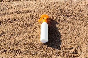 zonnebrand lotion wit fles Aan zand met kopiëren ruimte. sunblock spf room Aan de zee strand in zomer vakantie concept foto