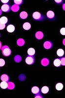 ongericht abstract Purper bokeh Aan zwart achtergrond. onscherp en wazig veel ronde licht foto