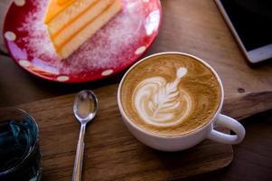 koffie aroma latte kunst kop en smakelijk Kerstmis taart Aan hout tafel vrije tijd in cafe koffie winkel foto