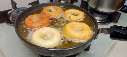 geassorteerd donuts met chocola bevroren, roze geglazuurd en hagelslag donuts. donuts in hand- of dienblad foto