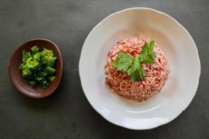 rood gestoomd rijst- of nasi merah geserveerd in bord geïsoleerd Aan zwart achtergrond foto