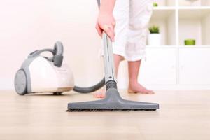 vrouw schoonmaak met vacuüm schoonmaakster foto