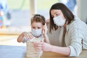 moeder en kind spelen samen Bij huis isolatie gedurende coronavirus pandemisch foto