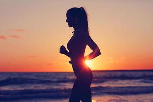 vrouw rennen alleen Bij mooi schemer Aan de strand foto