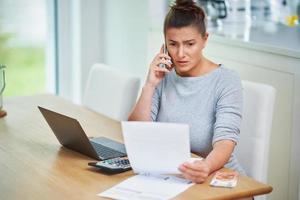 jong vrouw tellen huis begroting met rekeningen foto