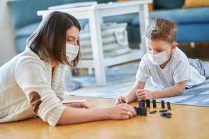 moeder en kind spelen samen Bij huis isolatie gedurende coronavirus pandemisch foto