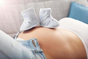 gelukkig zwanger vrouw resting Aan sofa foto