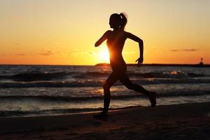 vrouw rennen alleen Bij mooi schemer Aan de strand foto