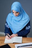moslim vrouw leerling aan het leren Bij huis foto