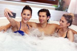 groep van vrienden genieten van jacuzzi in hotel spa foto