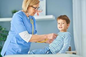 kinderarts dokter onderzoeken weinig kinderen in kliniek foto