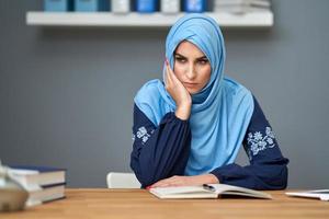 ongelukkig moslim vrouw leerling aan het leren Bij huis foto