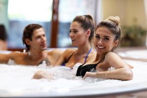 groep van vrienden genieten van jacuzzi in hotel spa foto