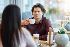 jong paar genieten van koffie en taart in cafe foto