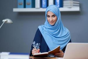 moslim vrouw leerling aan het leren Bij huis foto