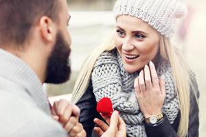 volwassen Mens geven verloving ring naar mooi vrouw foto