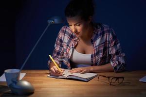 moe vrouw leerling aan het leren tot laat Bij huis foto