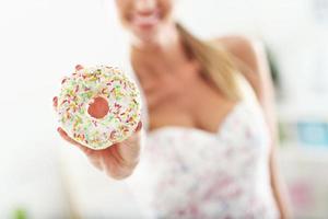 gelukkig vrouw met donut na training foto