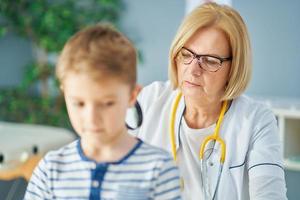 kinderarts dokter onderzoeken weinig kinderen in kliniek foto