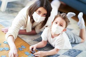 moeder en kind spelen samen Bij huis isolatie tijdens het coronavirus pandemisch foto