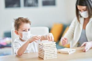 moeder en kind spelen samen Bij huis isolatie gedurende coronavirus pandemisch foto