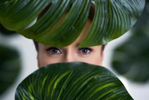 mooi volwassen vrouw poseren tegen blad achtergrond foto