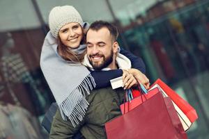 portret van gelukkig paar met boodschappen doen Tassen na boodschappen doen in stad foto