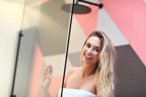 mooi blond Kaukasisch vrouw poseren in badkamer met nat haar- foto