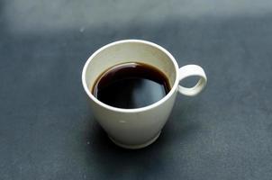 zwart koffie Aan wit glas, geïsoleerd met zwart achtergrond foto