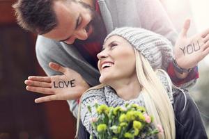 afbeelding tonen jong paar met bloemen dating in de stad foto