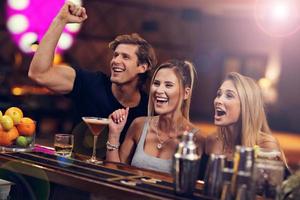 groep van vrienden genieten van drinken in bar foto