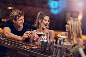 groep van vrienden genieten van drinken in bar foto