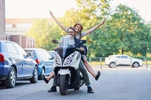 gelukkig volwassen paar rijden een scooter in de stad Aan een zonnig dag foto