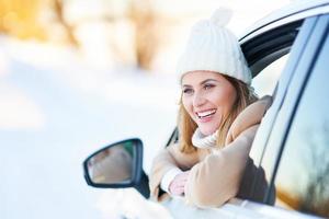 gelukkig vrouw het rijden auto in besneeuwd winter foto