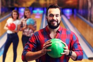 groep van vrienden spelen bowling foto