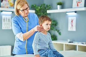 kinderarts dokter onderzoeken weinig kinderen in kliniek foto