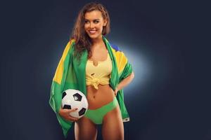 gelukkig braziliaans ventilator juichen met vlag en Amerikaans voetbal foto