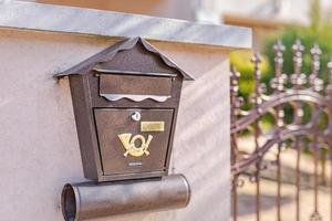 bruin brievenbus Aan modern huis muur met ijzer schutting. postbus, mail levering foto